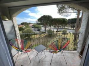 vistas a un patio con 2 sillas y un balcón en Résidence Margarita en Plage dʼArgelès