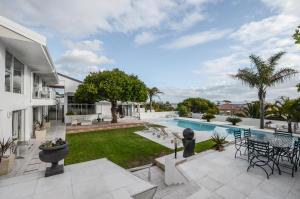 an exterior view of a house with a swimming pool at Capo Cabana Guesthouse in Plattekloof