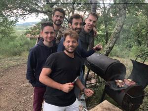 un groupe d'hommes debout à côté d'un grill dans l'établissement Chez Buddy - cabane de trappeur, à Peaugres