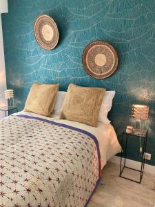 - une chambre avec un lit et un mur bleu dans l'établissement Superbe appartement avec jardin Saint Charles, à Biarritz