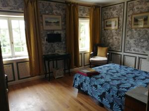 a bedroom with a bed and a desk and windows at Chambre Le Notre Le Domaine Des Jardins De Bracquetuit in Bracquetuit