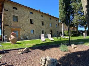 ein Gebäude mit einem Garten mit Stühlen davor in der Unterkunft Il Castagnolo B&B in San Gimignano