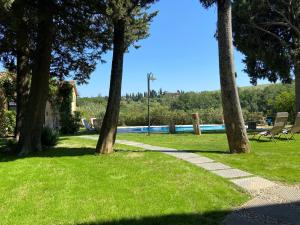 einen Garten mit Bäumen und einem Pool in der Unterkunft Il Castagnolo B&B in San Gimignano