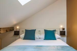 a bedroom with a bed with blue pillows at Chic 2BR in city center, next to Train Station in Chamonix