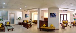 a lobby with couches and tables and yellow pillows at YWCA International Guest House in New Delhi