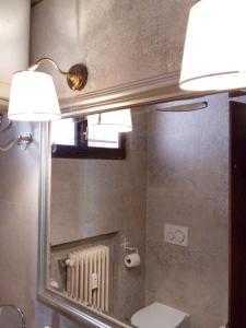 bagno con specchio, servizi igienici e lampada di Schönes Altstadt-Apartment ''Dolce Vita'' inkl Parkplatz a Riva del Garda Altre 39 foto
