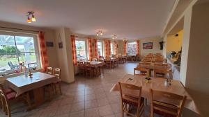 a restaurant with tables and chairs in a room at Pension Hanni in Ostseebad Sellin