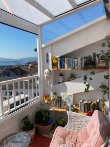 een kamer met een balkon en een boekenplank bij Ático acogedor en casco antiguo in Cangas de Morrazo