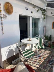 een patio met een tafel en stoelen op een veranda bij Ático acogedor en casco antiguo in Cangas de Morrazo