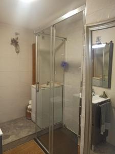 a bathroom with a glass shower and a sink at Ático acogedor en casco antiguo in Cangas de Morrazo