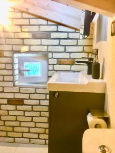 bagno con lavandino e muro di mattoni di Anna's cottage house a Perama Altre 78 foto