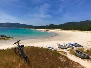 a bike parked on a hill next to a beach at Bonito bungalow con jardín en playa Nerga in Hio