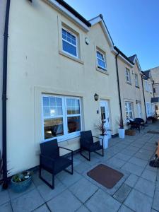 a patio with chairs and a table in front of a building at Beachcomber in Garlieston