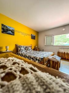 a bedroom with two beds and a yellow wall at Lugar dos Vales-Memorável, Encantador e Autêntico! in Mirandela