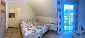 a small bedroom with a bed and blue curtains at Pokoje u Basi in Sromowce Niżne