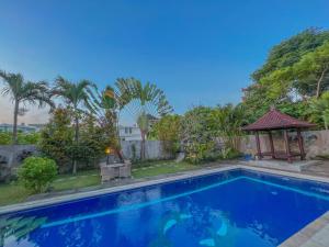 a swimming pool with a gazebo next to a house at Villa Senyum in Canggu