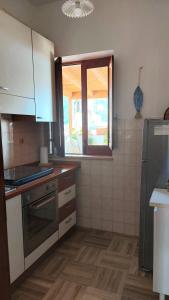a kitchen with a stove and a window at Casa Crispi 10 in Gioiosa Marea