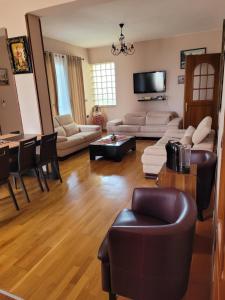 Una sala de estar con sofás y una mesa. en Villa Angela, en Vlorë