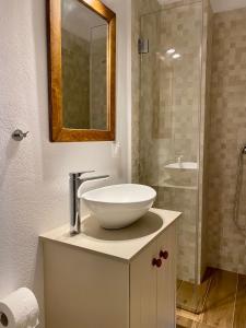 a bathroom with a bowl sink and a shower at Myconian Old Town Maisonette THE MIMIs PLACE in Mikonos