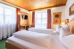 Postel nebo postele na pokoji v ubytování Das Maximilian - Feines Landhotel am Schliersee