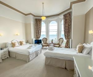 a hotel room with two beds and a large window at St Kilda Hotel in Llandudno