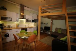a kitchen and living room with a table and a bunk bed at Sääse Apartments in Pärnu