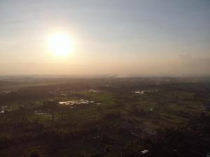 an aerial view of a city with the sun in the sky at Ubad Retreat in Ubud