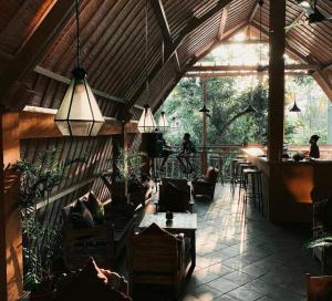 a room with people sitting in chairs in a restaurant at Ubad Retreat in Ubud