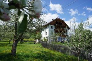 a house in a field with a fence and trees at Hainererhof in Mauterndorf