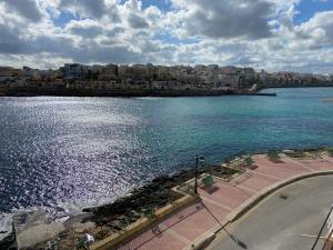 una vista de un cuerpo de agua con una ciudad en Sea front retro style apartment en Marsaskala