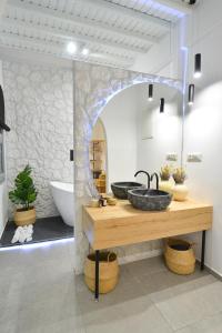 a bathroom with two sinks and a bath tub at Oikia Suites Mykonos in Mýkonos City