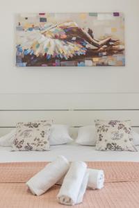 a bed with two rolled towels and a painting at Family Apartments Jadrijević in Primošten +29 photos