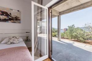 a bedroom with a bed and a large window at Family Apartments Jadrijević in Primošten