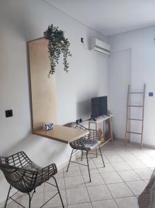 Zimmer mit einem Tisch, Stühlen und einem Schreibtisch in der Unterkunft Blue Lagoon Studio 2 in Mesolongi