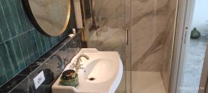 y baño con lavabo y ducha con espejo. en Casa Allegri en Alguer
