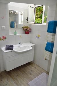 een witte badkamer met een wastafel en een spiegel bij Le Jardin Paris in Ivry-sur-Seine