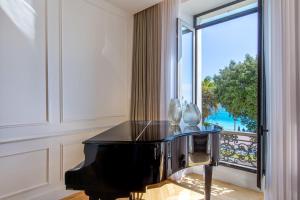 a black piano in a room with a large window at QUAI PROMENADE Brand-new! In front of the sea next to the old town in Nice
