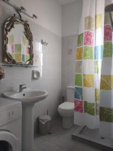 a bathroom with a sink and a toilet and a mirror at Despoina SEASIDE APARTMENT AGIOS KONSTANTINOS SAMOS in Ágios Konstantínos