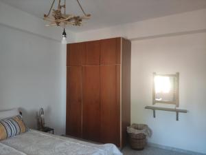 a bedroom with a wooden cabinet next to a bed at Despoina SEASIDE APARTMENT AGIOS KONSTANTINOS SAMOS in Ágios Konstantínos