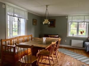 a dining room with a wooden table and chairs at Fråsttorp in Aneby