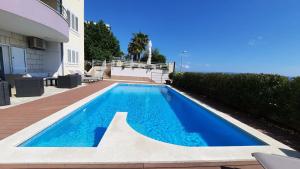 a swimming pool in front of a house at SEA VIEW- spacious apartment with shared pool in Split