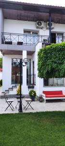 Garden Lounge Hotel في يريفان: مقعد احمر امام مبنى ابيض