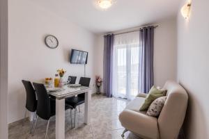 a living room with a table and a couch at Family Apartments Jadrijević in Primošten