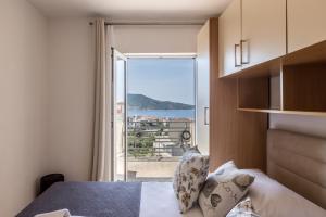 a bedroom with a bed and a view of the ocean at Family Apartments Jadrijević in Primošten