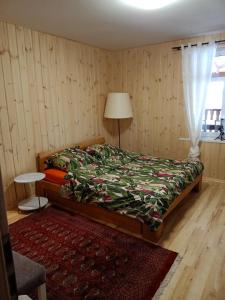 a bedroom with a bed and a table and a window at Agroturystyka Podlasie in Dobrzyniewo Duże