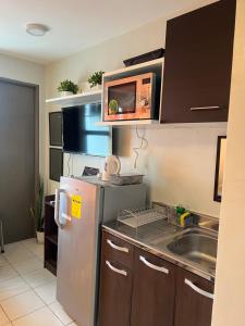 a kitchen with a refrigerator and a sink at Cozy Boo Staycation near Enchanted kingdom by Dynel in Santa Rosa