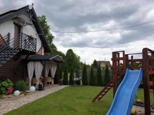 un parque infantil con un tobogán azul en un patio en Country House - apartamenty blisko Energylandii, en Spytkowice