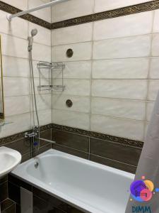 a bathroom with a bath tub and a sink at Dimm Отель in Almaty