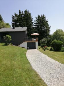a gravel driveway leading to a house with an umbrella at Chalet Dionysos in Murat-le-Quaire