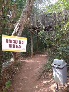 un panneau qui dit indico da trinidad à côté d'une poubelle dans l'établissement Ecologic Ville Resort - Oficial, à Caldas Novas